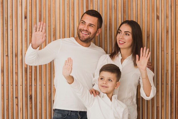 Portrait of parents with son waiving