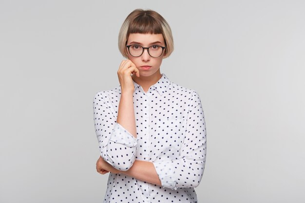 Portrait of pensive attractive blonde young woman wears polka dot shirt