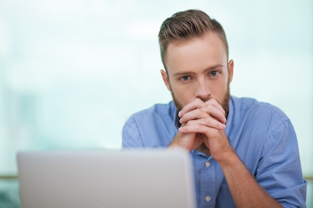 Portrait of pensive businessman at laptop