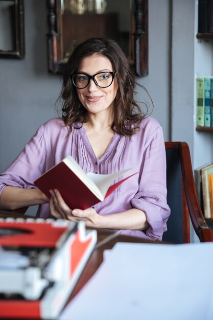 Portrait of a pensive mature authoress in eyeglasses