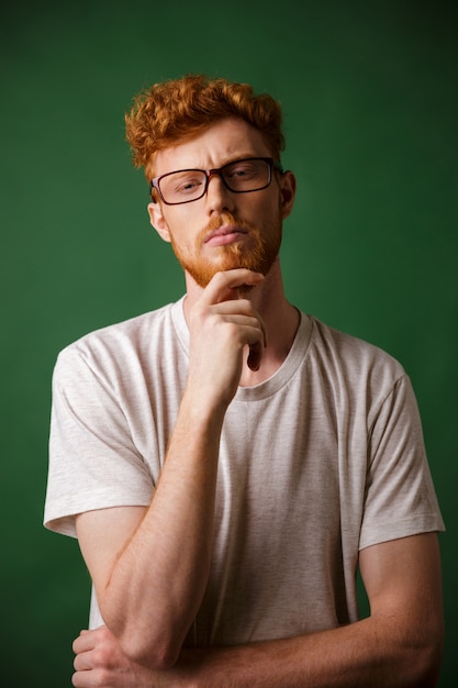 Portrait of a pensive redhead man in eyeglasses