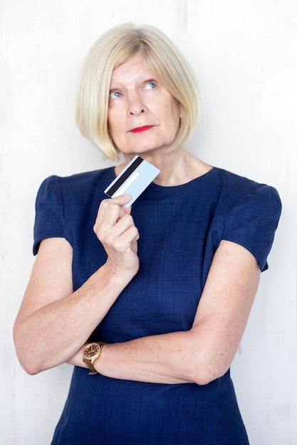 Free photo portrait of pensive senior woman with credit card