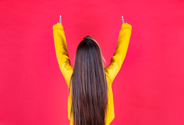 Portrait photo of a beautiful girl model standing and pointing up