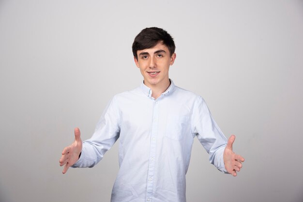 Portrait photo of a smiling man standing and showing size with hands