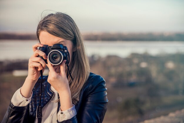 彼女の顔をカメラで覆う写真家の肖像画。 Ph