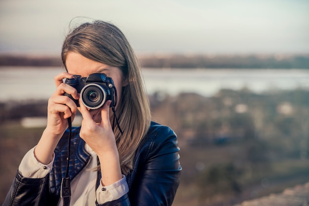 Portrait of a photographer covering her face with the camera. Ph