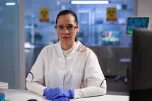Free photo portrait of physician woman doctor sitting at table during biochemistry experiment