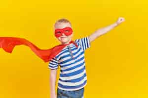 Free photo portrait of playful boy in superhero costume