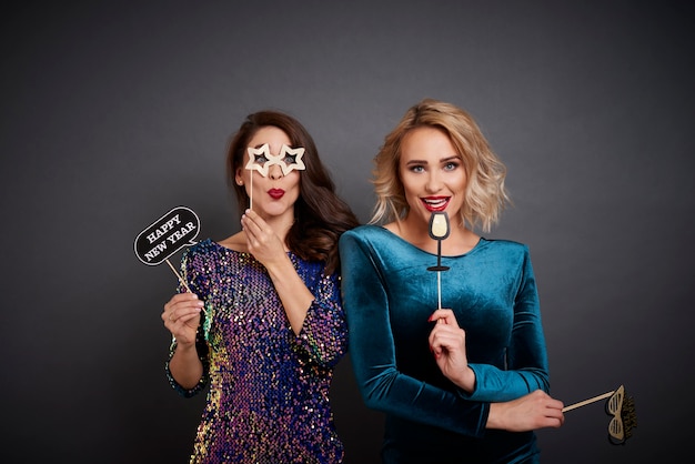 Free photo portrait of playful women with photo booth partying