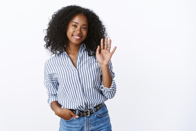 Portrait pleasant friendly african american female waving hand