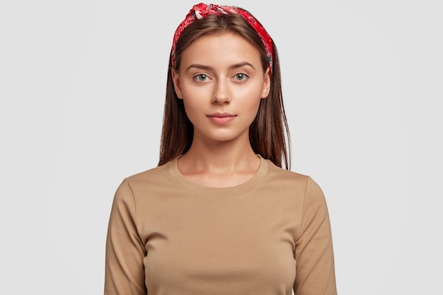 Free photo portrait of pleasant looking young student posing against the white wall