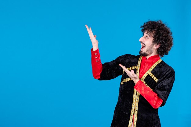 Portrait of pleased azeri man in traditional costume on blue background ethnic dancer novruz spring