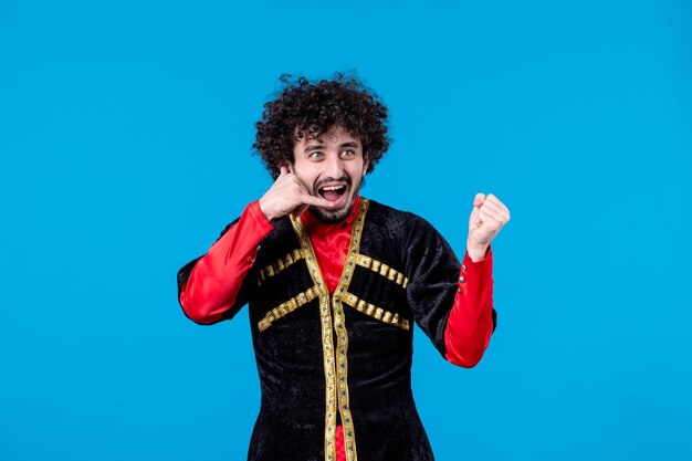 Portrait of pleased azeri man in traditional costume studio shot blue background spring novruz ethnic dancer