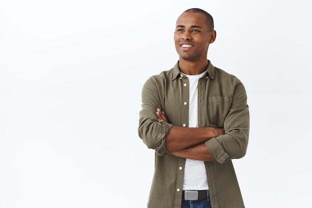 Free photo portrait of pleased and proud handsome africanamerican man cross arms on chest confident contemplating something pleasant smiling delighted look left satisfied white background