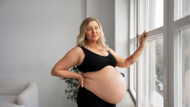 Foto gratuita ritratto di una donna incinta in taglia plus