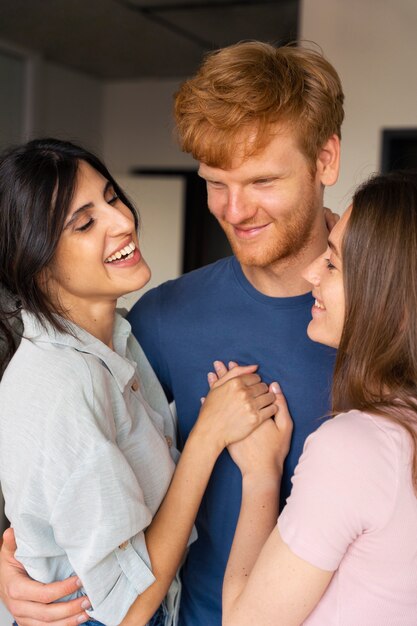 Portrait of polyamorous couple at home showing affection