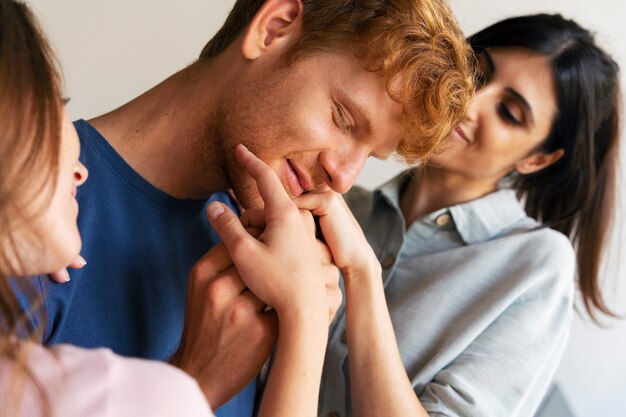 Portrait of polyamorous couple at home showing affection