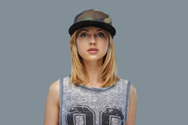 Free photo portrait of positive blond female in baseball cap. isolated on grey background.