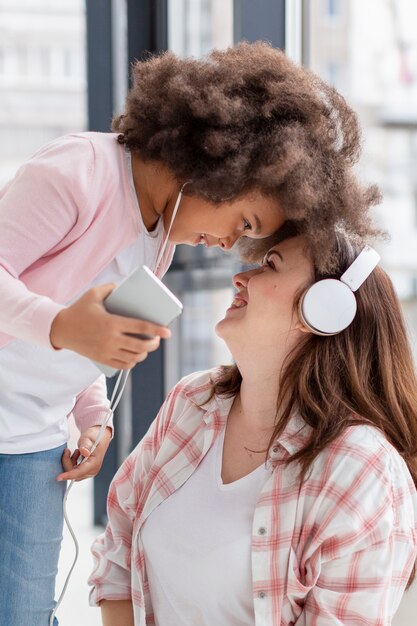 Portrait of positive mother playing with daughter