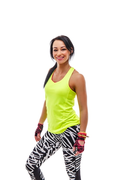 Portrait of positive smiling sporty female in green sportswear isolated on white background.