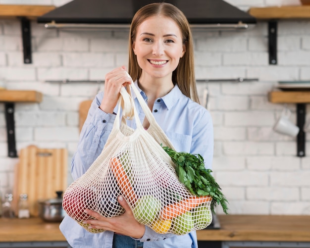 Portrait of positive woman proud of organic vegetables