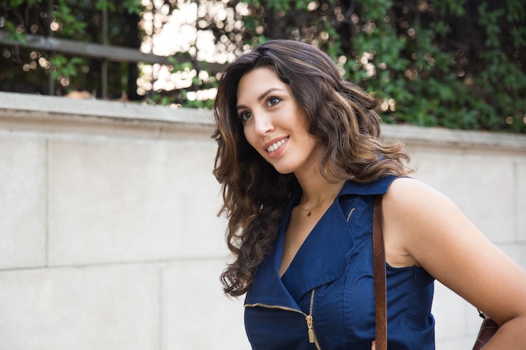 Free Photo portrait of positive young woman walking in street