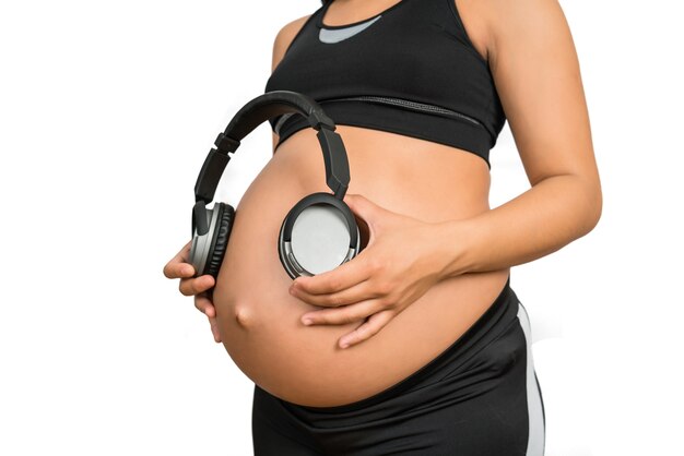 腹にヘッドフォンを保持している妊婦の肖像画