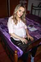 Free photo portrait of a pregnant woman with laptop looking at camera