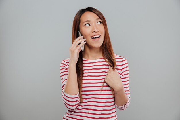 Портрет довольно азиатские девушки говорят на мобильном телефоне