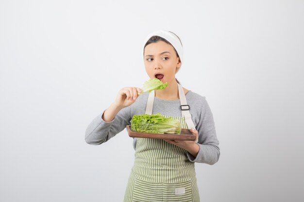 Portrait of a pretty cute woman eating fresh lettuce 