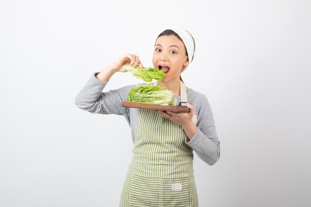 Portrait of a pretty cute woman eating fresh lettuce 