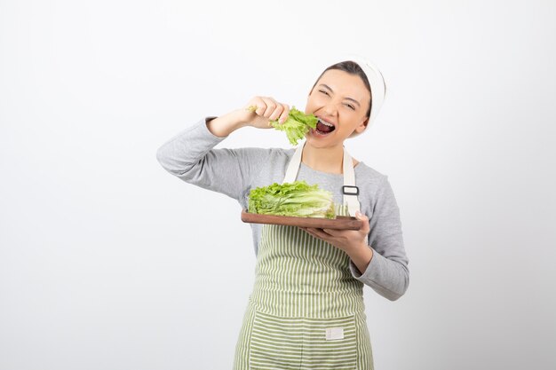 Portrait of a pretty cute woman eating fresh lettuce 