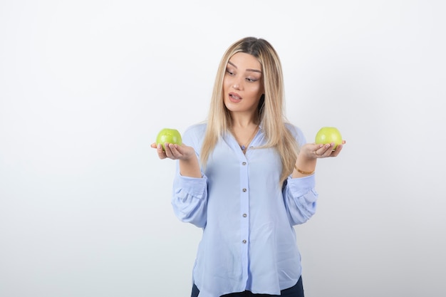 portrait of a pretty girl model standing and holding fresh apples.