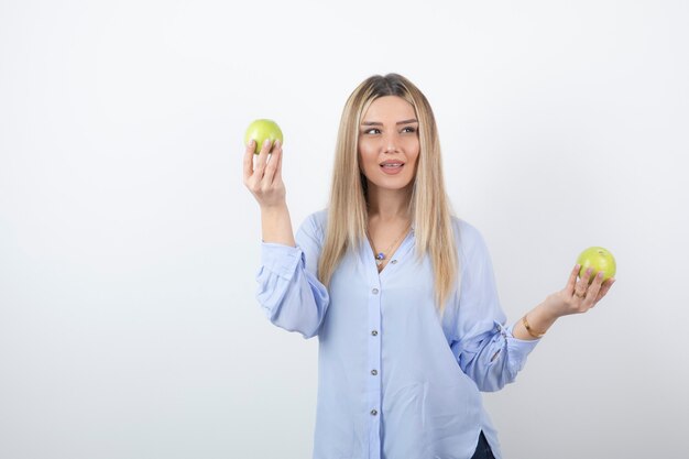 portrait of a pretty girl model standing and holding fresh apples.