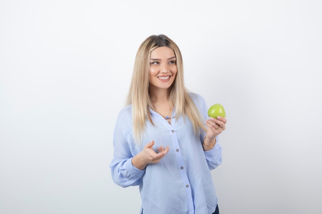 Portrait pretty girl model standing and holding a green fresh apple.