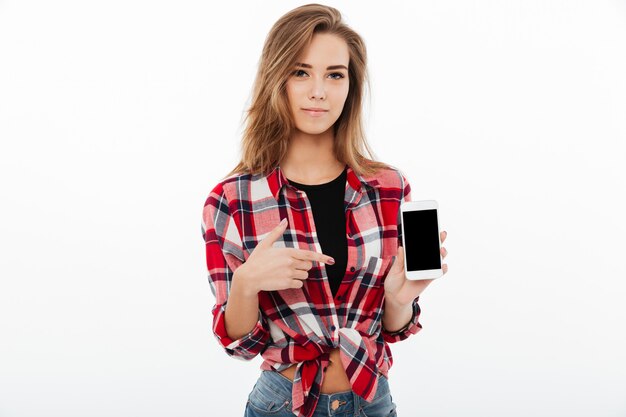 Portrait of a pretty girl in plaid shirt pointing finger