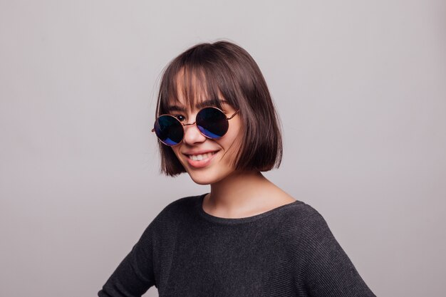 Portrait of pretty girl teenager in sunglasses isolated.