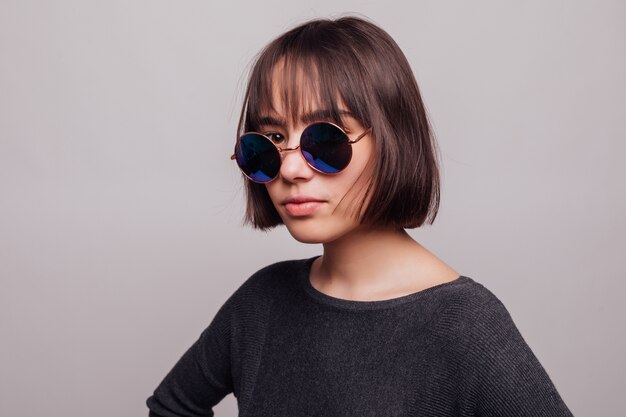 Portrait of pretty girl teenager in sunglasses isolated.