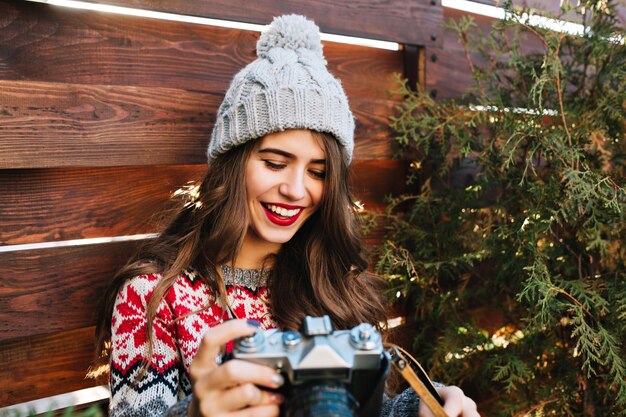 木製の手で笑っている冬の帽子で雪の白の笑顔で肖像画のかわいい女の子。