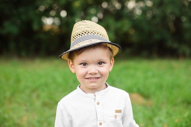 Portrait of pretty little boy in stylish clothes walks outside