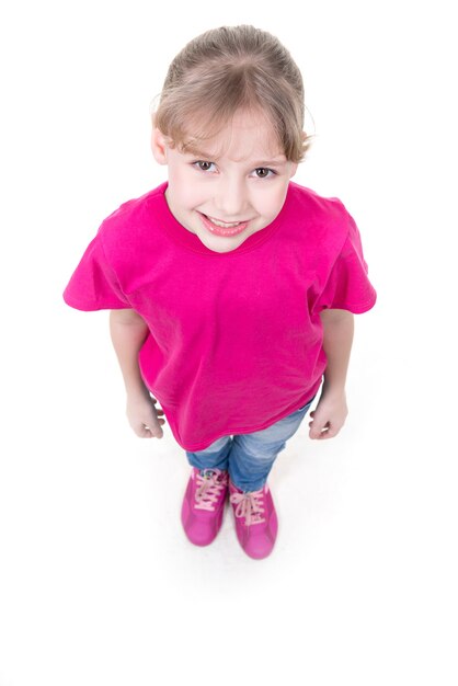 Portrait of pretty little girl looking up in pink t-shirt. Top view. Isolated on white background.