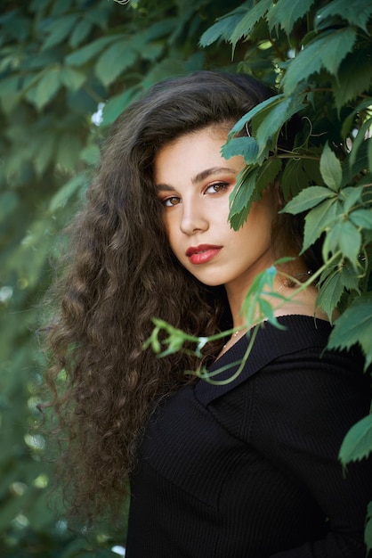 Portrait of pretty model among grape leaves