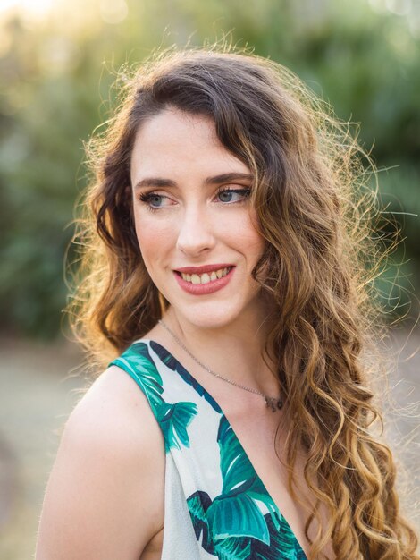 Portrait of a pretty smiling Spanish female with curly long hair