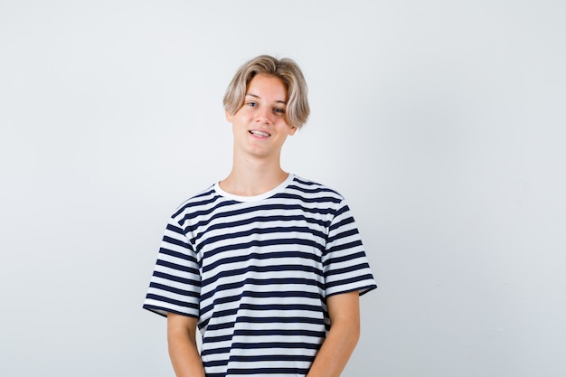 Portrait of pretty teen boy posing in striped t-shirt and looking cheerful front view