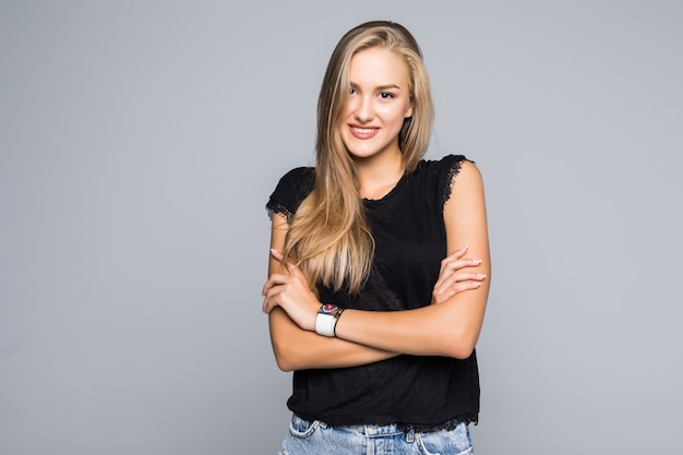 Portrait of pretty trendy woman with beaming smile with crossed arms looking at camera isolated on grey background