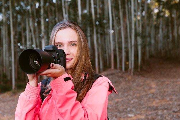 Portrait of a pretty woman holding camera