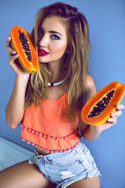 Portrait of pretty woman holding tasty sweet tropical papaya