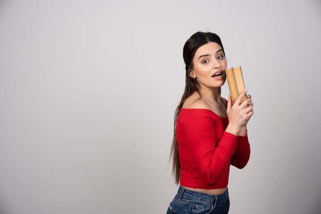 Portrait of a pretty woman holding two books.