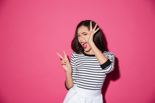 Portrait of a pretty woman showing peace gesture