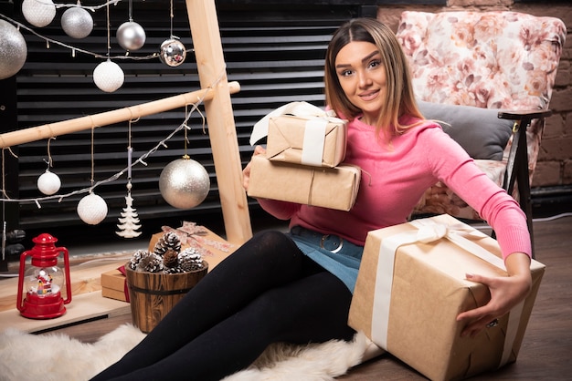 Portrait of pretty woman sitting and holding a Christmas present.